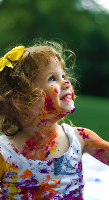 Photographie d'une petite fille pleine de peinture