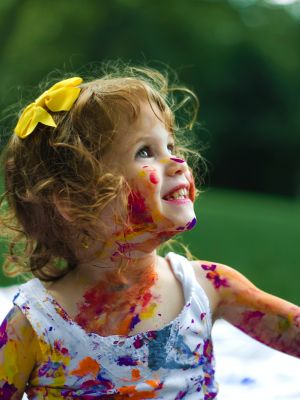 Photographie d'une petite fille pleine de peinture